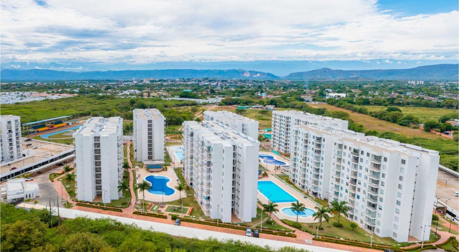 Vista aérea del conjunto Aqualina Orange con piscinas y montañas