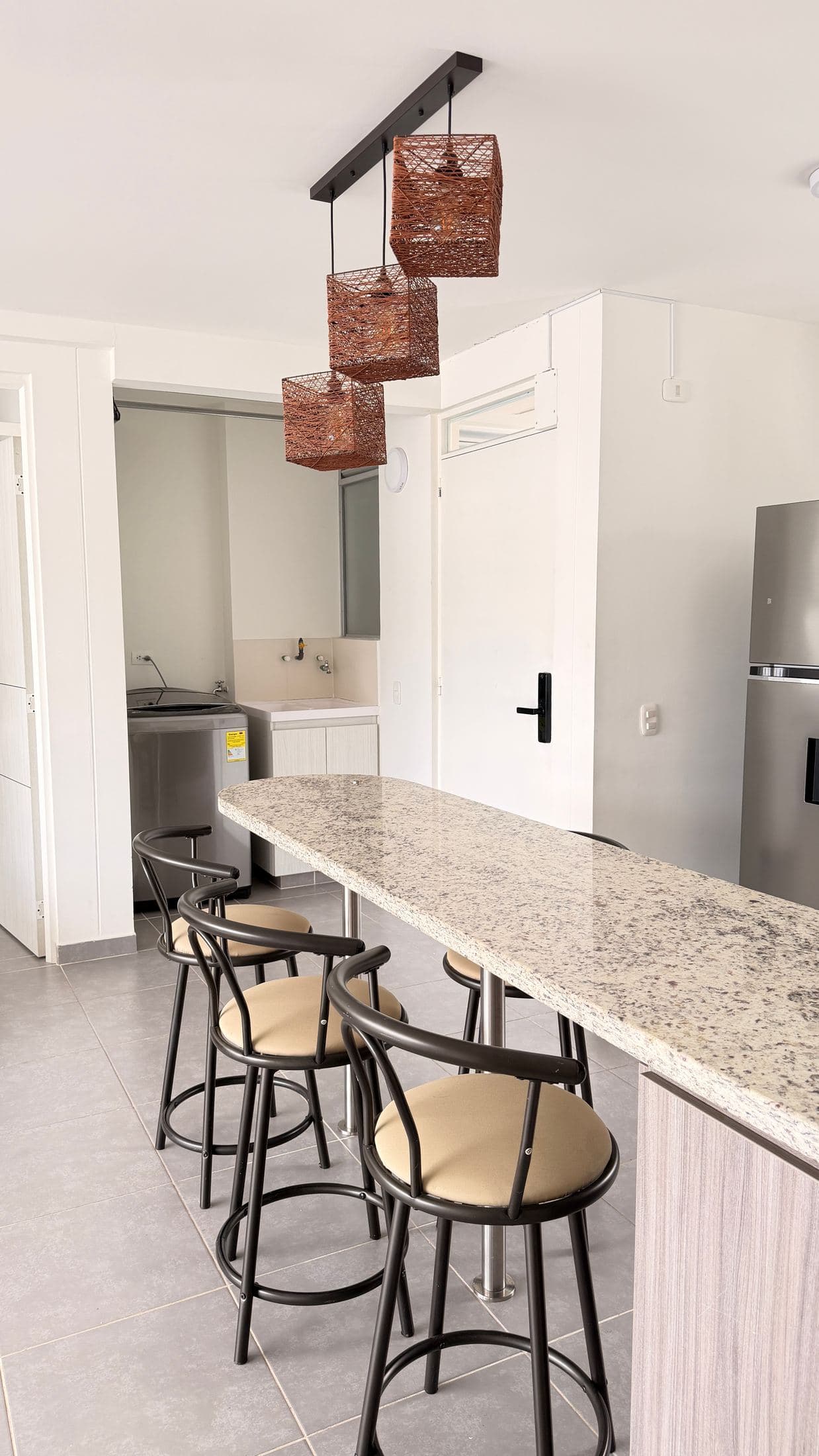 Comedor con barra de granito y lámpara artesanal